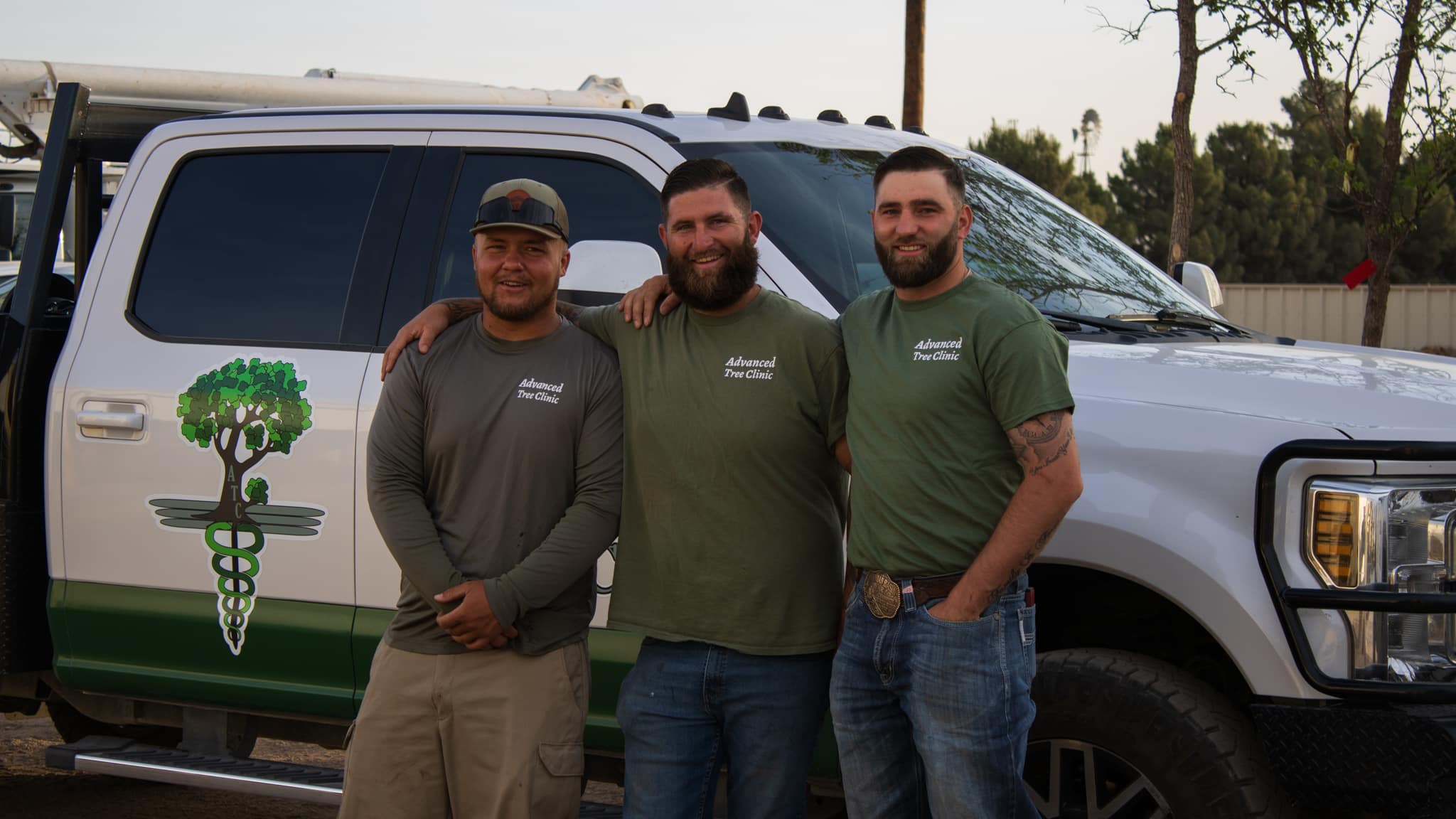 three workers posing in front of truck