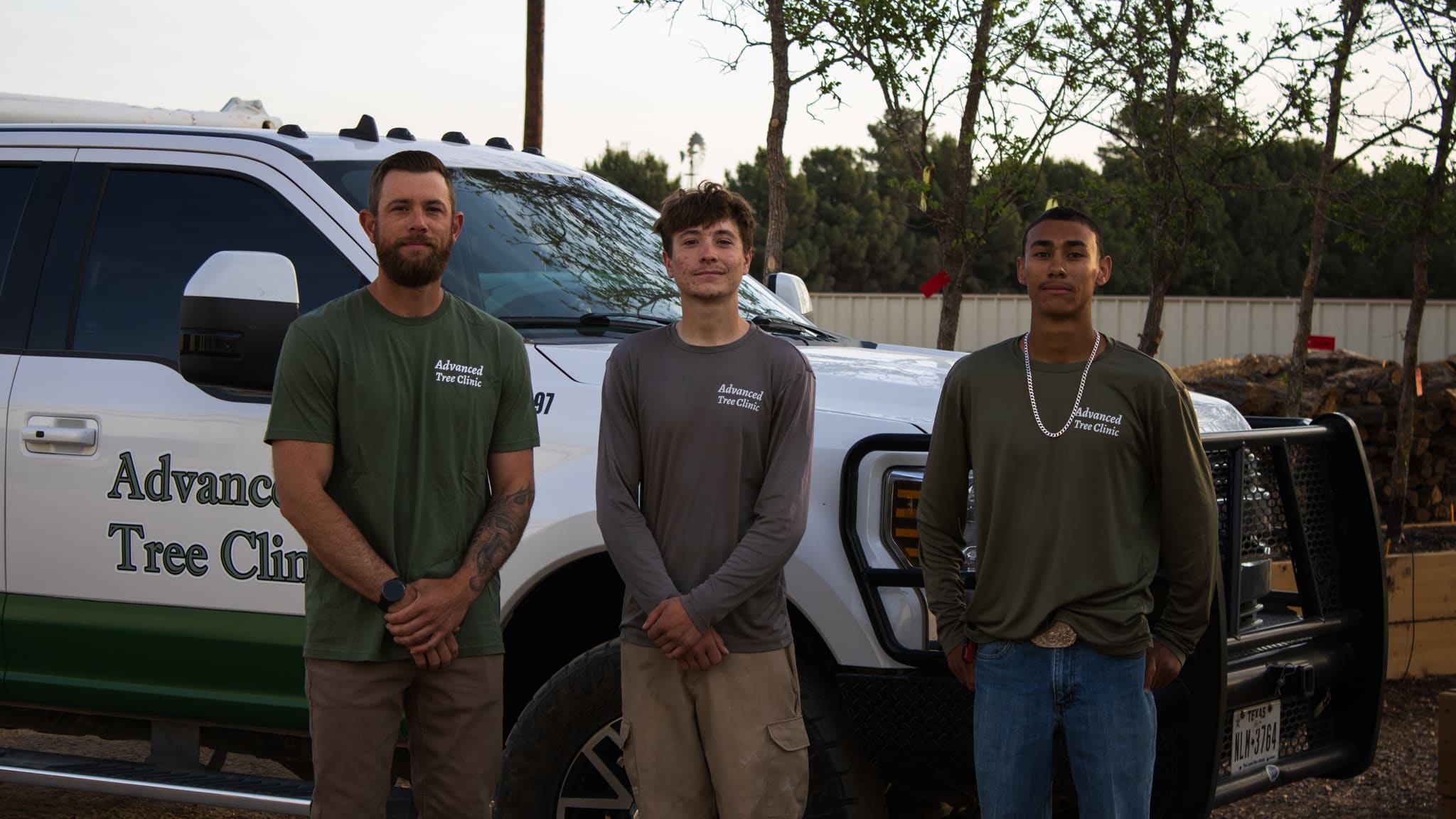 three workers posing in front of truck